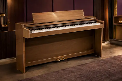 Piano numérique à 88 touches en finition bois naturel, avec trois pédales, présenté dans un studio épuré.