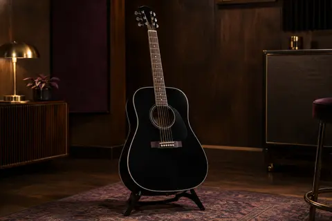 Guitare acoustique dreadnought noire Fender CD-60 posée seule sur un support dans un studio chaleureux.