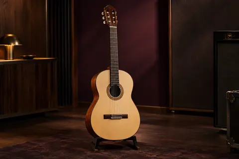 Guitare classique acoustique en bois naturel, avec table en épicéa, posée sur un support dans un studio chaleureux.
