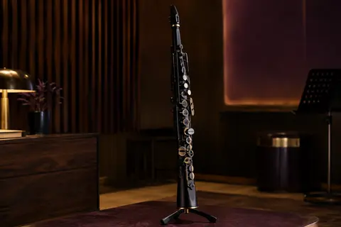 Saxophone numérique noir Yamaha YDS-120 présenté seul sur un support dans un studio chaleureux