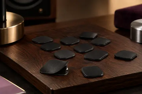 Lot de huit coussinets d’embouchure noirs en silicone posé sur un support en bois sombre